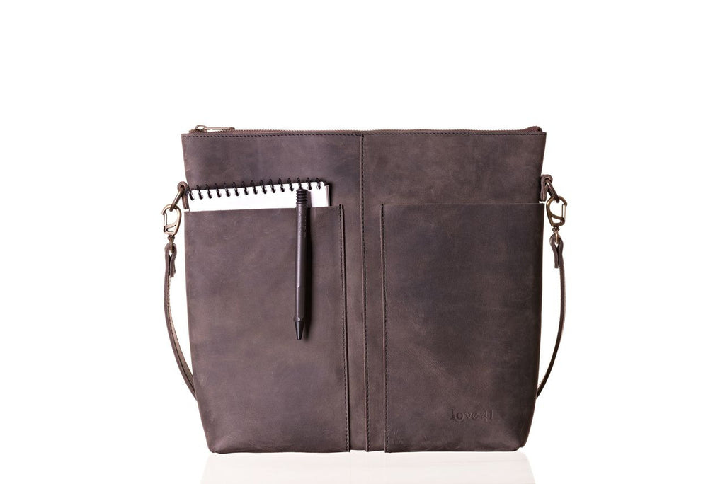 Minimal Leather Bag in dark brown, front view with a notebook and pen tucked in the slip pocket