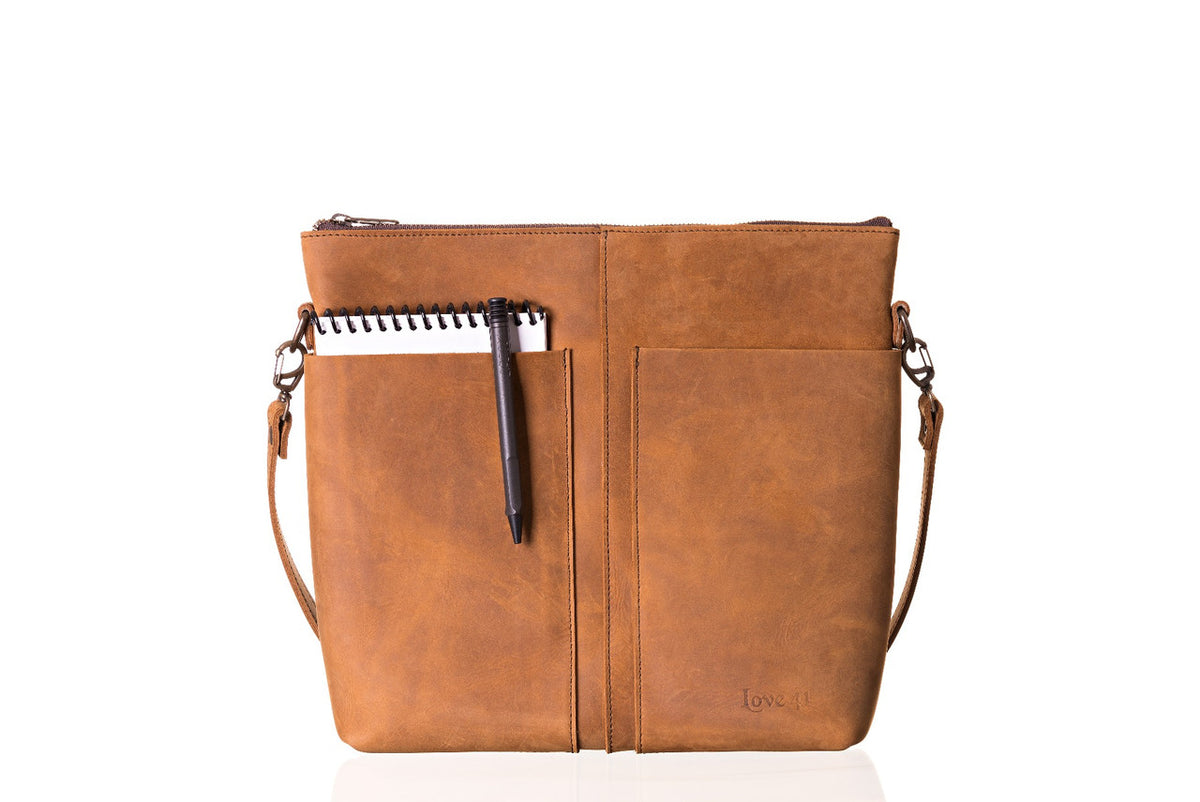 Minimal Leather Bag in cognac, front view with a notebook and pen tucked in the slip pocket