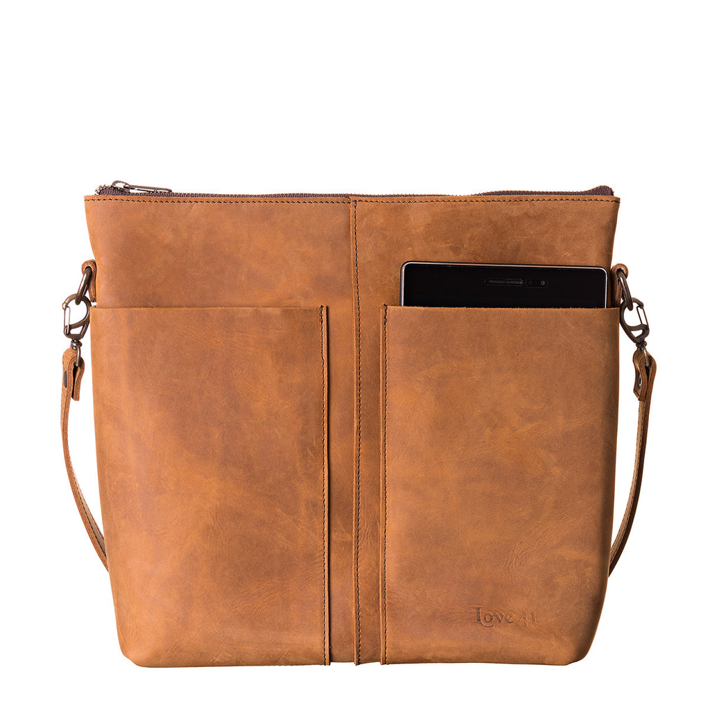 Minimal Leather Bag in cognac, close front view with a phone tucked in the slip pocket