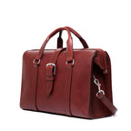 Spurgeon Briefcase in Oxblood, angled side view showing the buckle strap and shoulder strap clip
