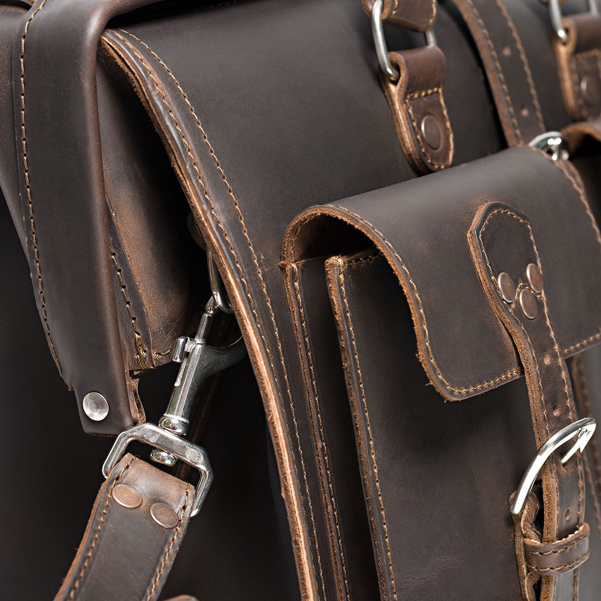 Barrister's Briefcase in Dark Coffee Brown, close-up of the buckled front pocket, stitching and swivel strap clip