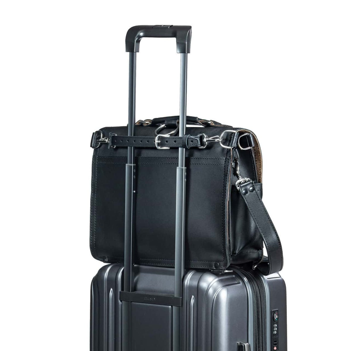 Leather Luggage Strap in Black holding a black leather bag on top of a rolling suitcase by its handle