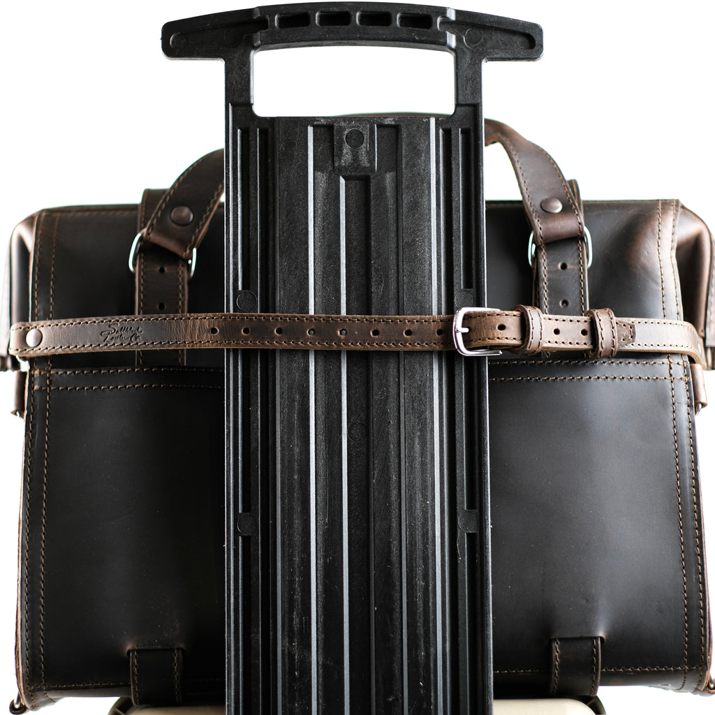 Leather Luggage Strap in Dark Coffee Brown buckled around a briefcase to secure it to a rolling suitcase handle