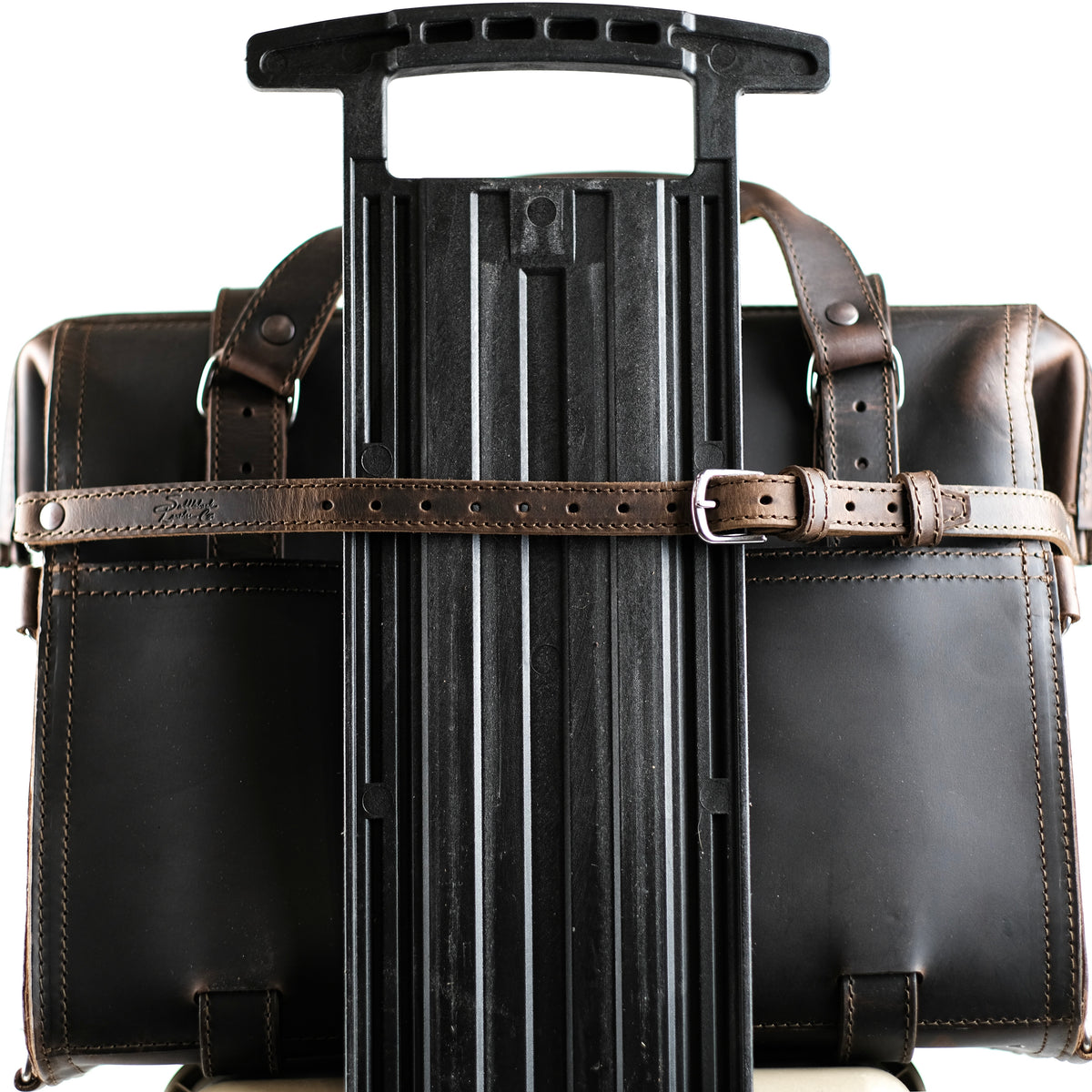 Leather Luggage Strap in Dark Coffee Brown buckled around a briefcase to secure it to a rolling suitcase handle
