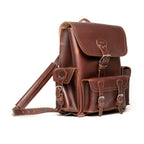 Front Pocket Leather Backpack in Chestnut, angled view with buckled flap, front pockets and strap
