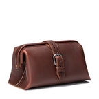 Big Mouth Leather Toiletry Bag in Chestnut, angled side view with buckle strap closure