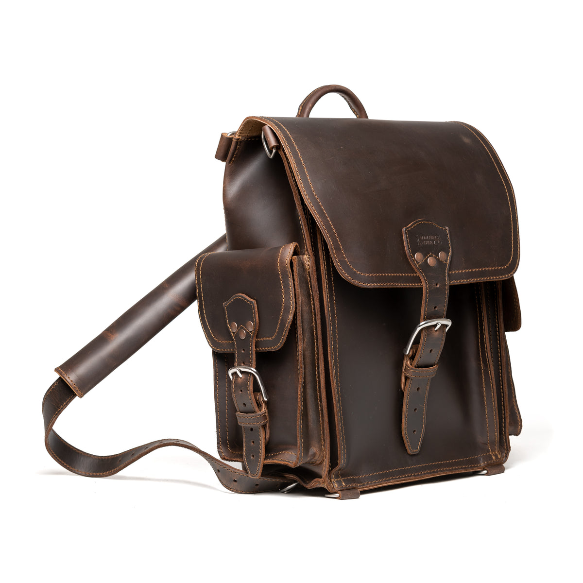 Tank Backpack in Dark Coffee Brown, angled view with buckled flap, side pocket and shoulder strap