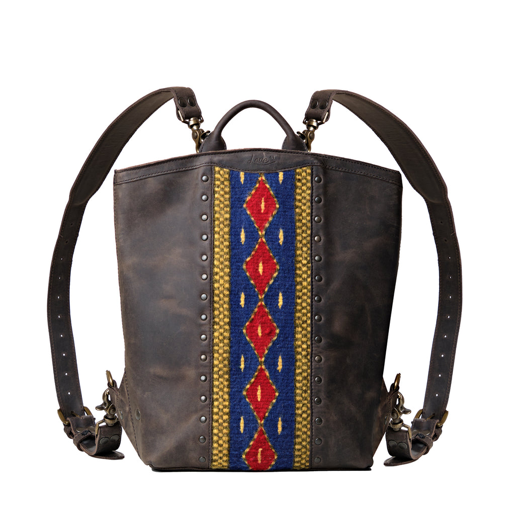 Lanita Leather Backpack in charcoal gray, front view with blue and red woven panel, studs and top handle