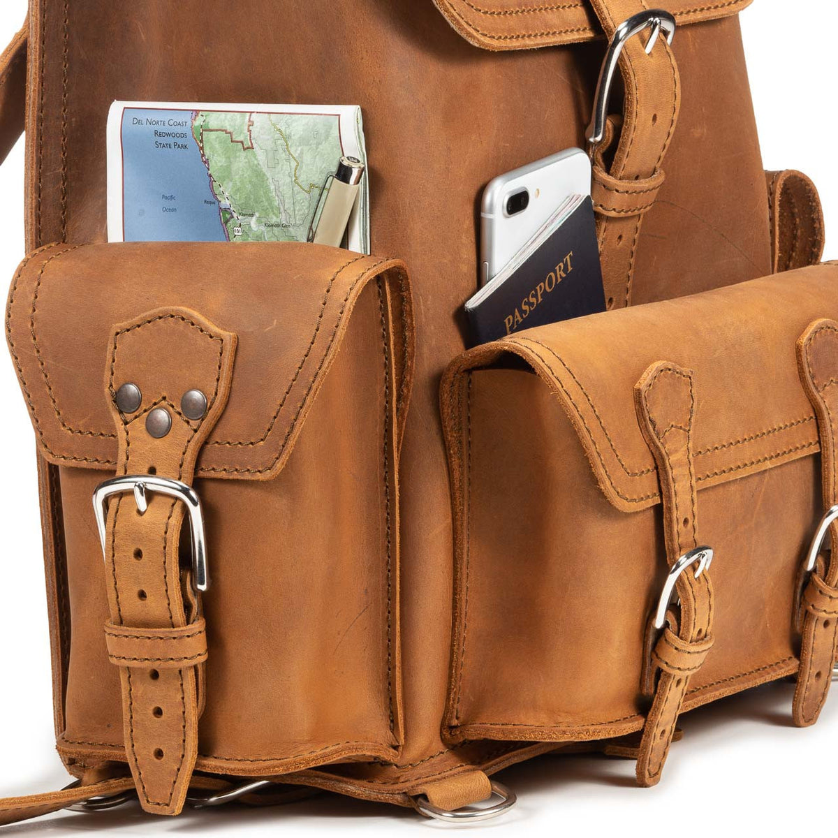 Front Pocket Leather Backpack in Tobacco, close-up of front pockets holding a map, phone and passport