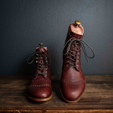 Officer's Boot in Oxblood, pair with shoe trees, one boot raised on a stand