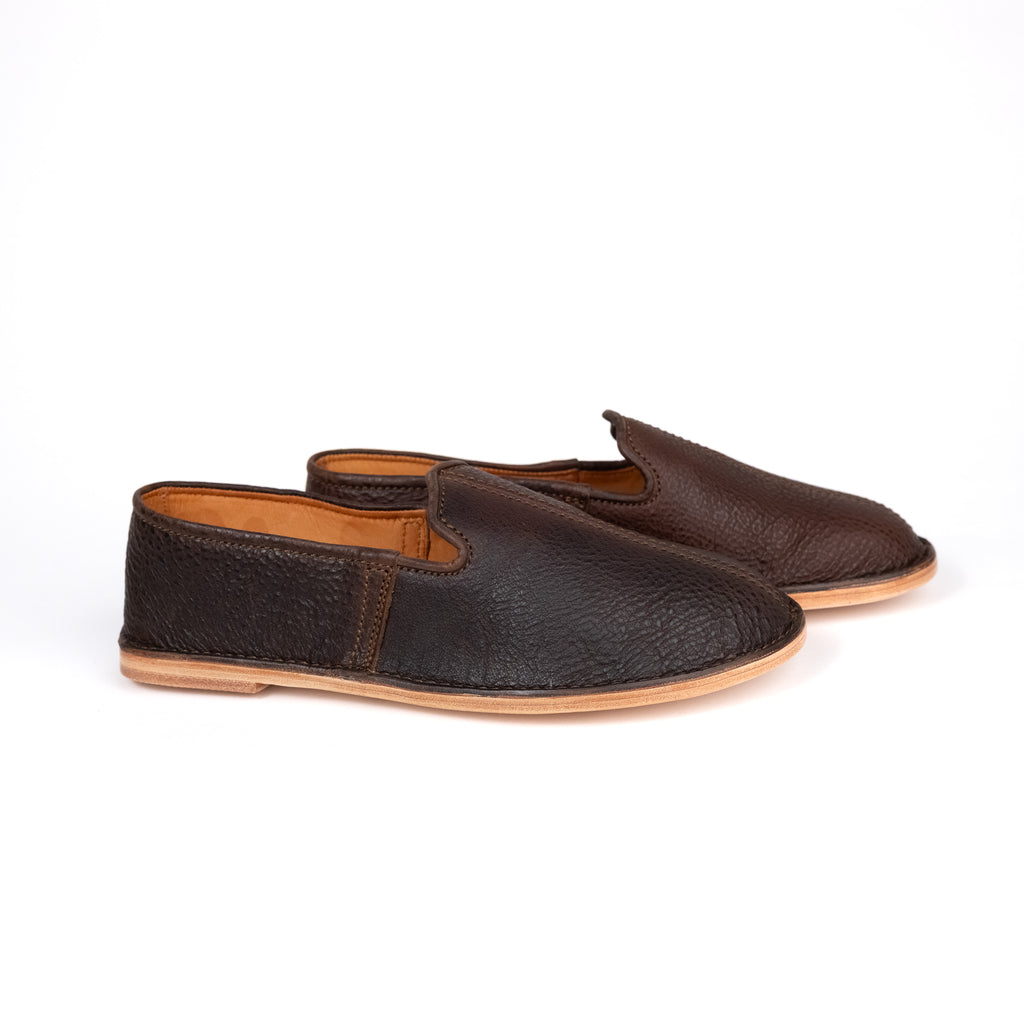 Pair of Barefoot Slip-on Shoes in Dark Coffee Brown leather with natural soles, side angled view