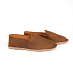 Pair of Barefoot Slip-on Shoes in Tobacco leather with natural soles, side angled view