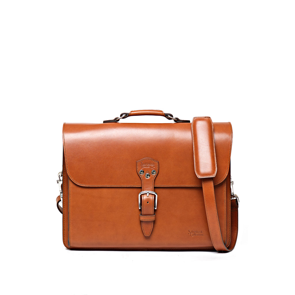 Livingstone Briefcase in English Tan, front view with buckled flap, top handle and shoulder strap