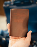 Pocket Declaration/Constitution in Chestnut held in one hand, embossed title on the cover