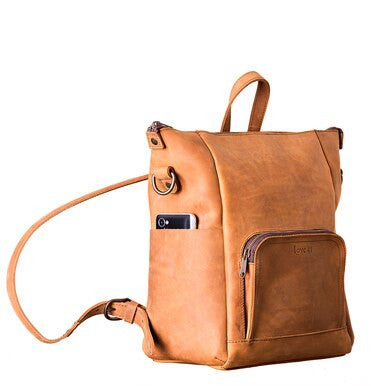 Universal Leather Backpack in Tobacco, angled view with a phone in the side pocket
