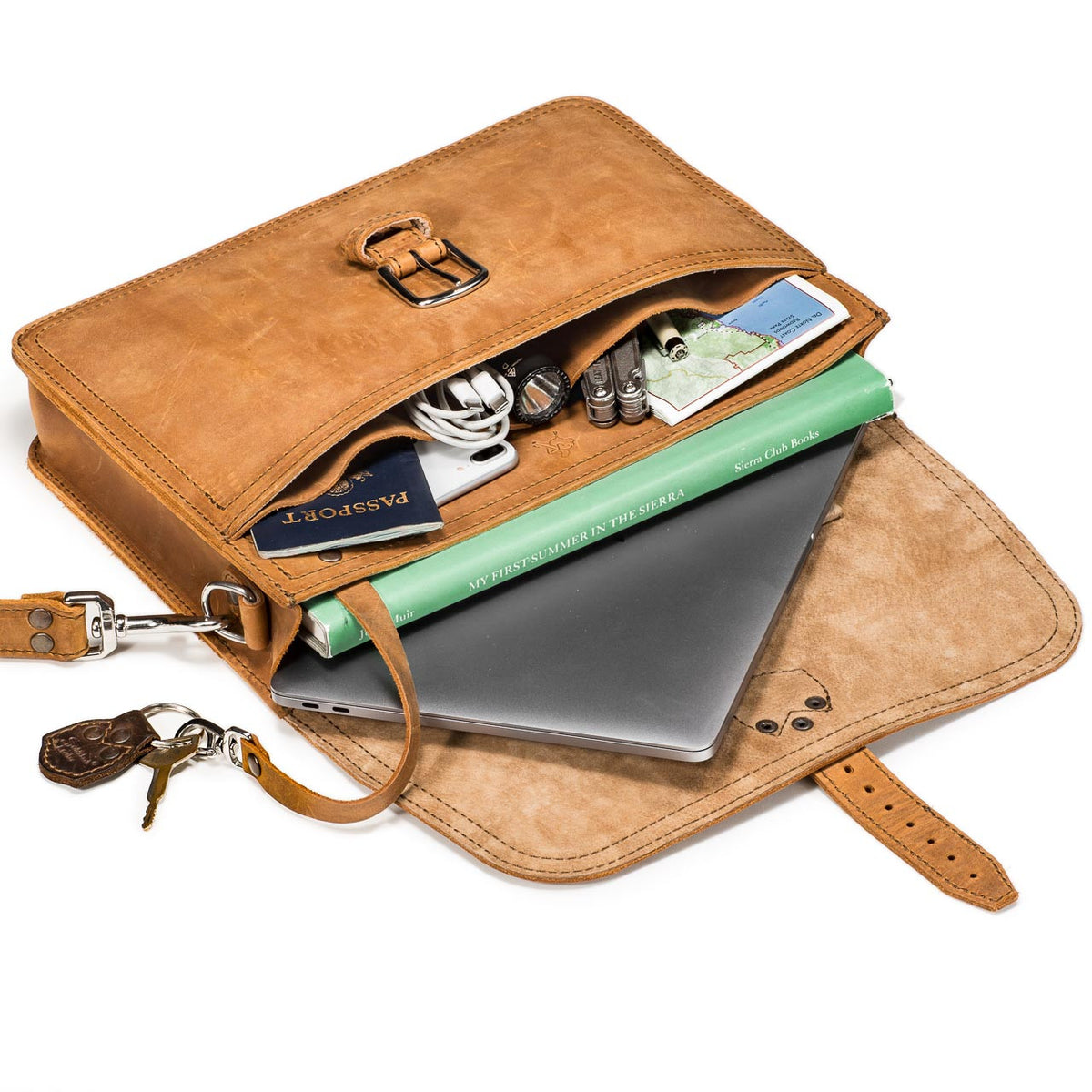 Fourteener Thin Leather Briefcase in Tobacco, flap open showing a laptop, notebook, passport, cables and keys inside