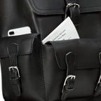 Thin Front Pocket Leather Backpack in Black, close-up of front pockets holding a phone and a park map