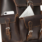 Thin Front Pocket Leather Backpack in Dark Coffee Brown, close-up of front pockets holding a phone and a park map
