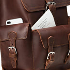 Thin Front Pocket Leather Backpack in Chestnut, close-up of front pockets holding a phone and a park map