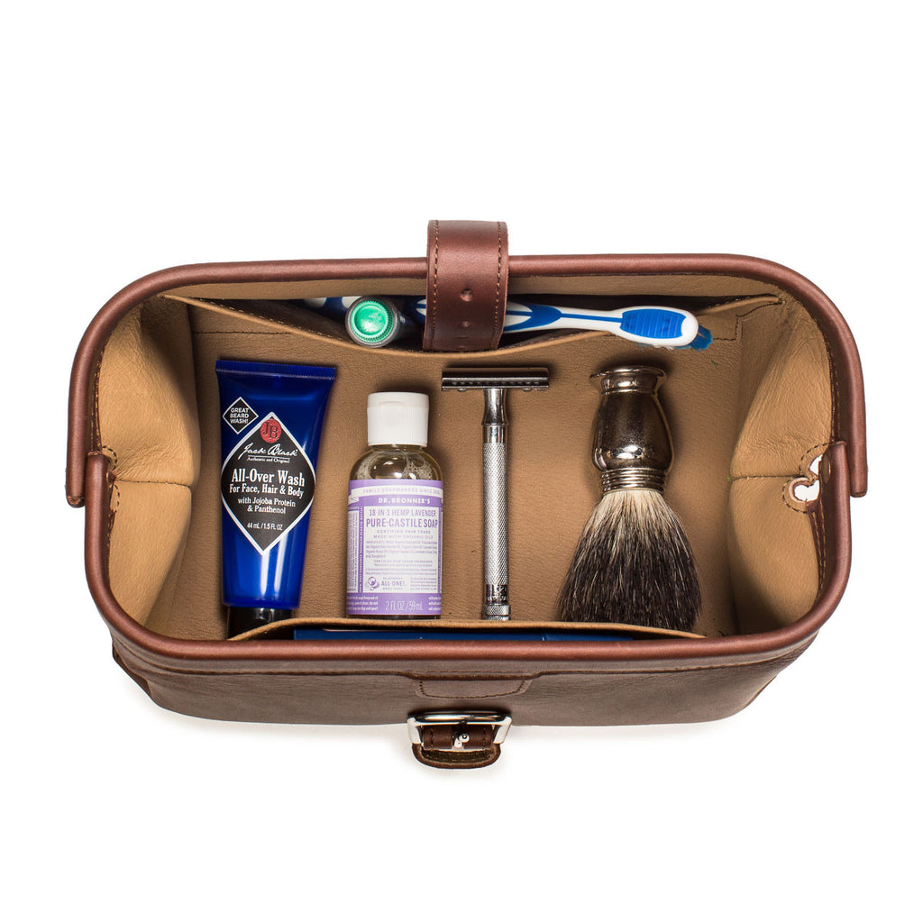 Big Mouth Leather Toiletry Bag in Chestnut, top-down view of open bag holding toothbrush, razor and shaving brush