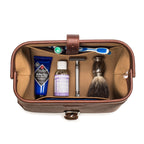 Big Mouth Leather Toiletry Bag in Chestnut, top-down view of open bag holding toothbrush, razor and shaving brush