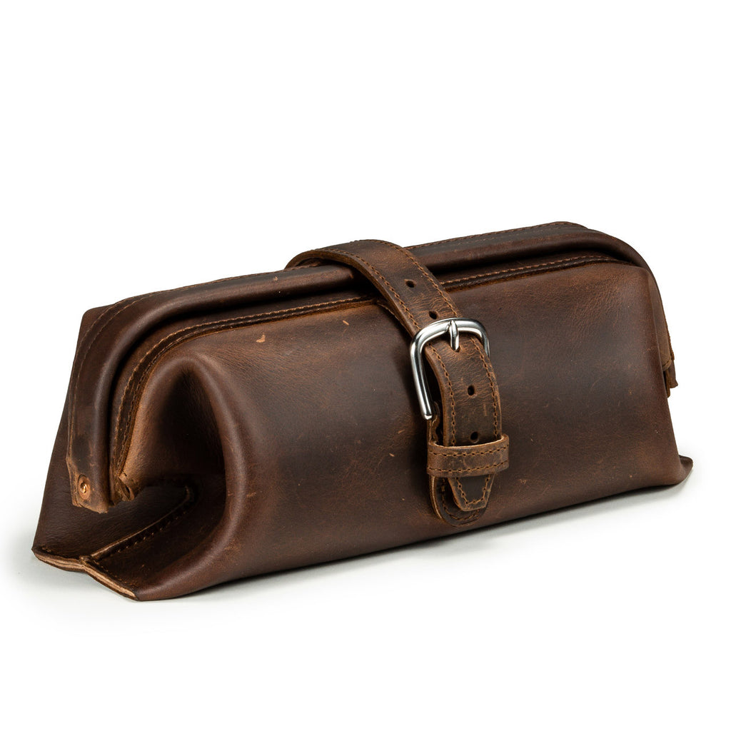 Little Big Mouth Toiletry Bag in Dark Coffee Brown, angled front view with wide frame opening and buckled strap closure