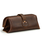 Little Big Mouth Toiletry Bag in Dark Coffee Brown, angled back view with riveted strap tab and embossed logo