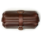 Little Big Mouth Toiletry Bag in Chestnut, top view closed with the leather strap buckled over the frame