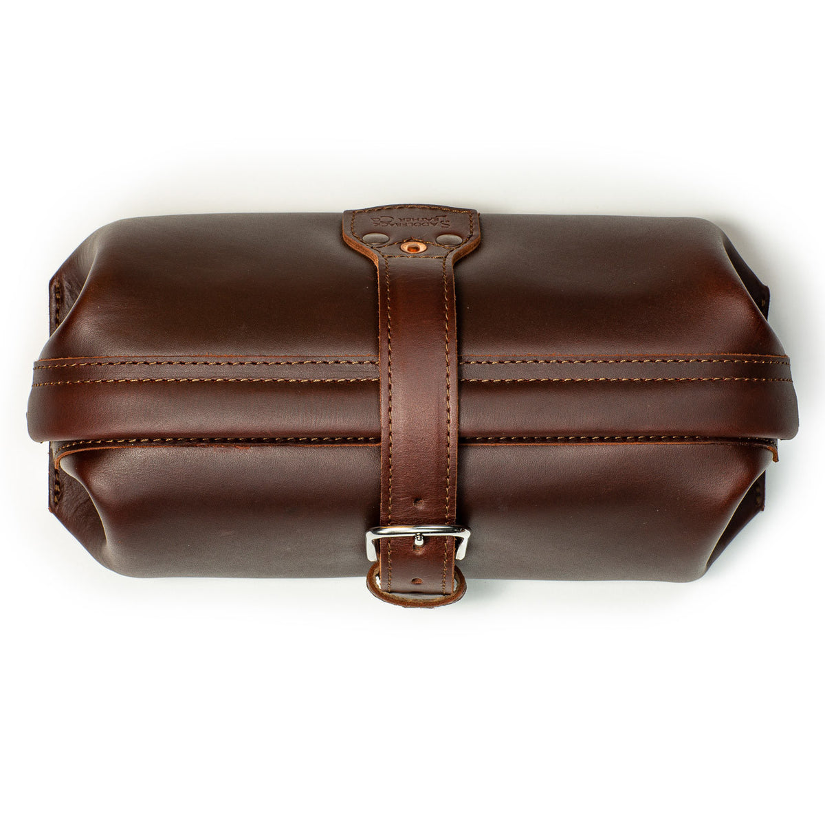 Little Big Mouth Toiletry Bag in Chestnut, top view closed with the leather strap buckled over the frame