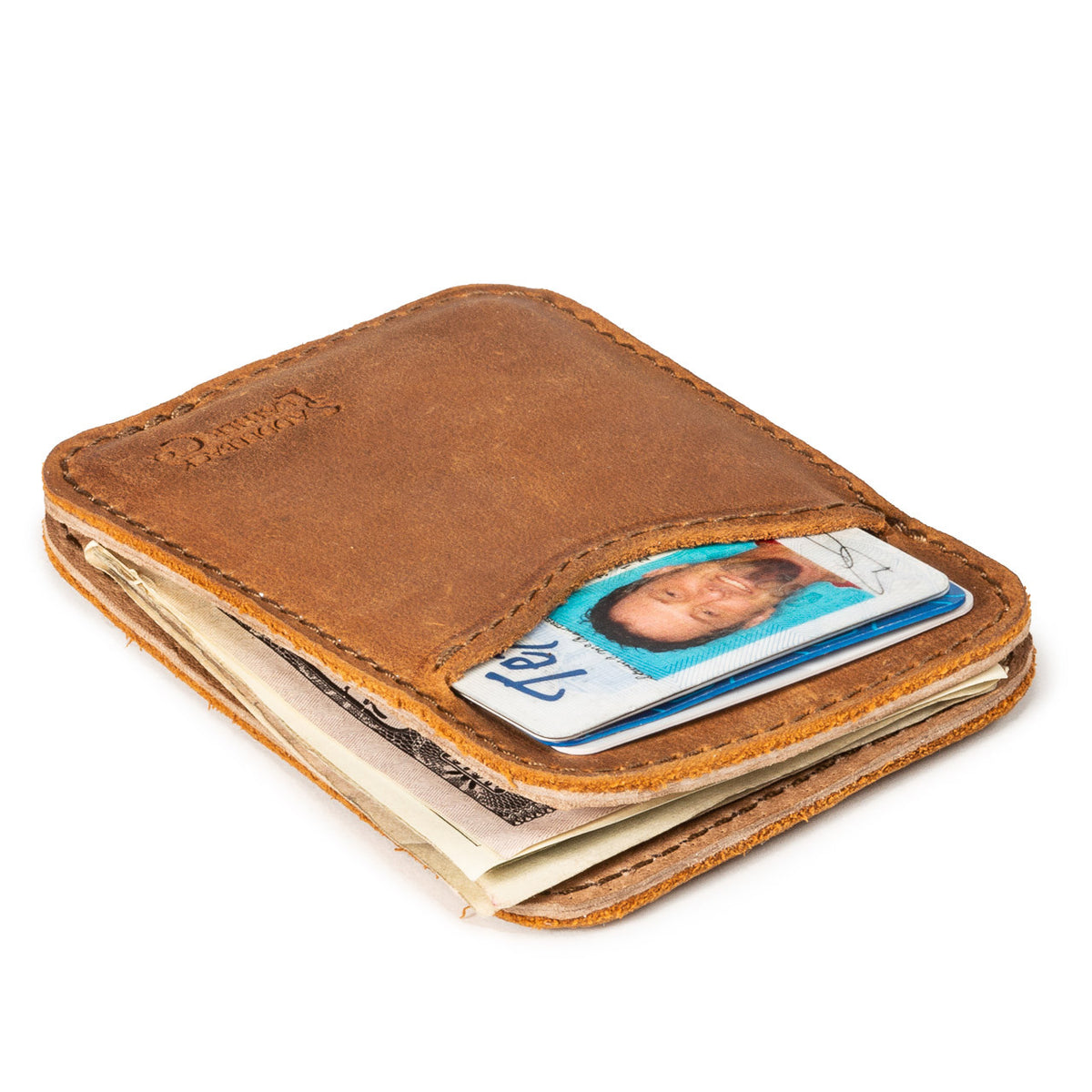 Slim Leather Card Wallet in Tobacco lying flat at an angle, loaded with an ID, cards and cash