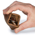 Bear Trap Leather Coin Purse in Tobacco squeezed open by a hand to reveal a stack of coins inside