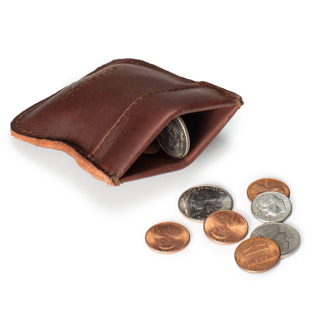 Bear Trap Leather Coin Purse in Chestnut squeezed open to show coins inside, with coins scattered beside it