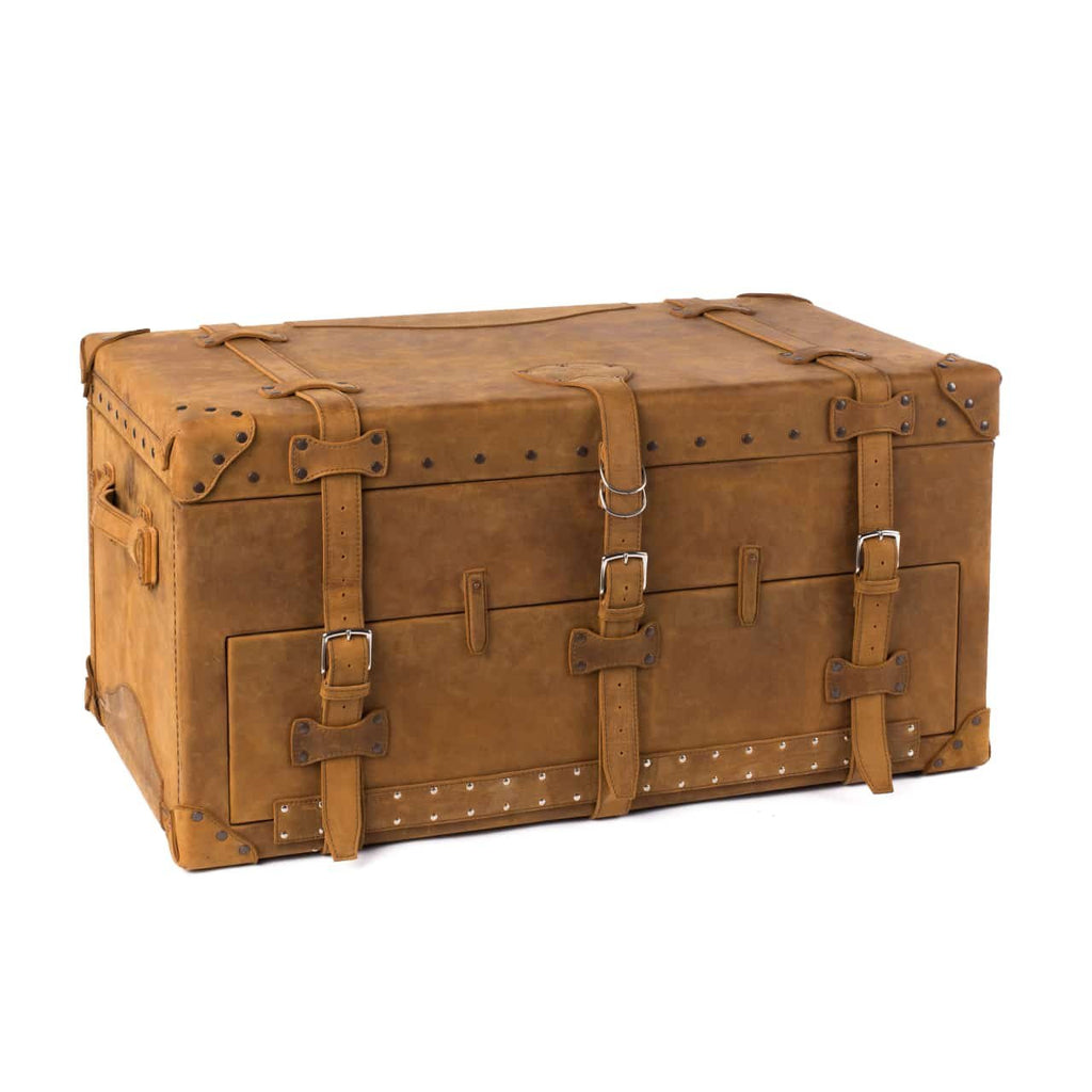 Leather Trunk in Tobacco, closed angled view with buckled straps, side handle and studded trim