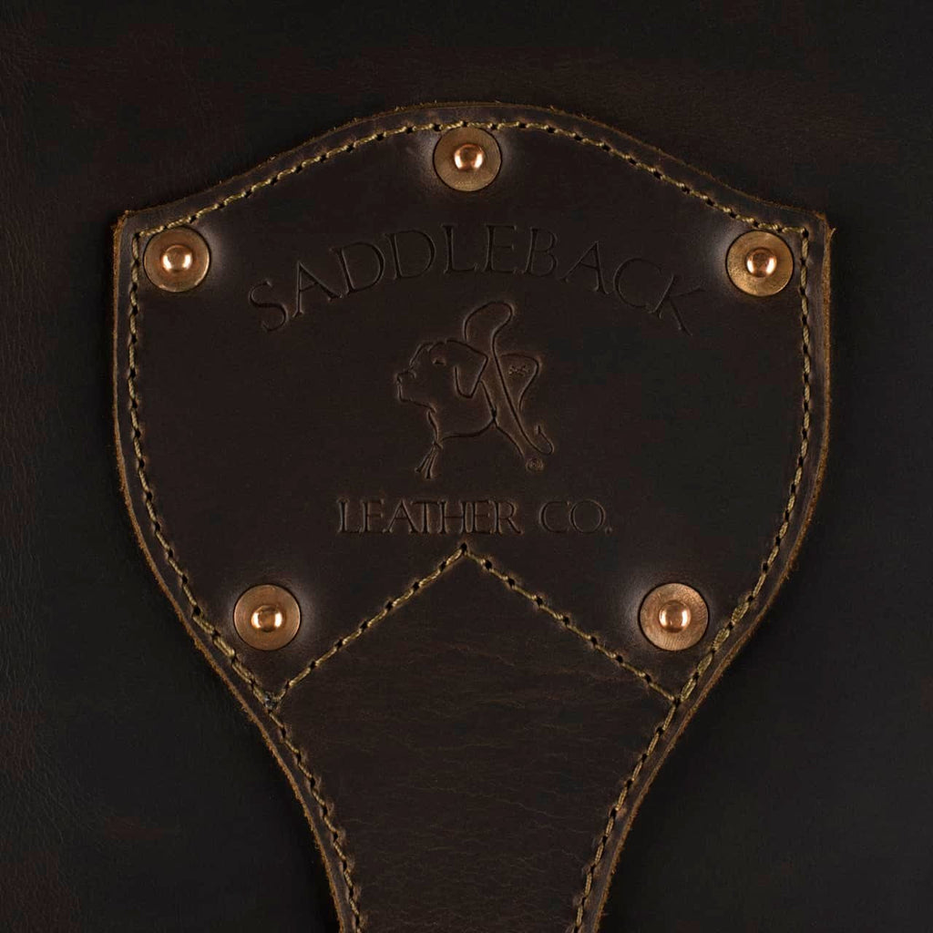 Leather Trunk in Dark Coffee Brown, close-up of riveted shield patch embossed with Saddleback Leather Co. logo