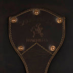 Leather Trunk in Dark Coffee Brown, close-up of riveted shield patch embossed with Saddleback Leather Co. logo
