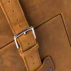 Leather Trunk in Tobacco, close-up of stitched strap with silver buckle and riveted anchor tab