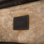 Leather Trunk in Dark Coffee Brown, close-up of stitched logo patch on the suede interior of the lid