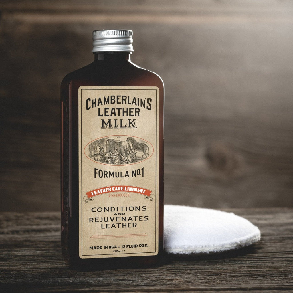 Chamberlain's Liniment No. 1 leather conditioner bottle beside an applicator pad on a wooden surface