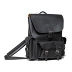 Front Pocket Leather Backpack in Black, angled view with buckled flap, front pockets and strap