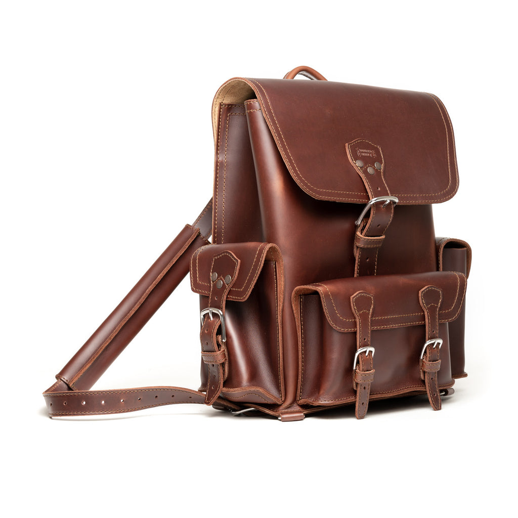 Front Pocket Leather Backpack in Chestnut, angled view with buckled flap, front pockets and strap