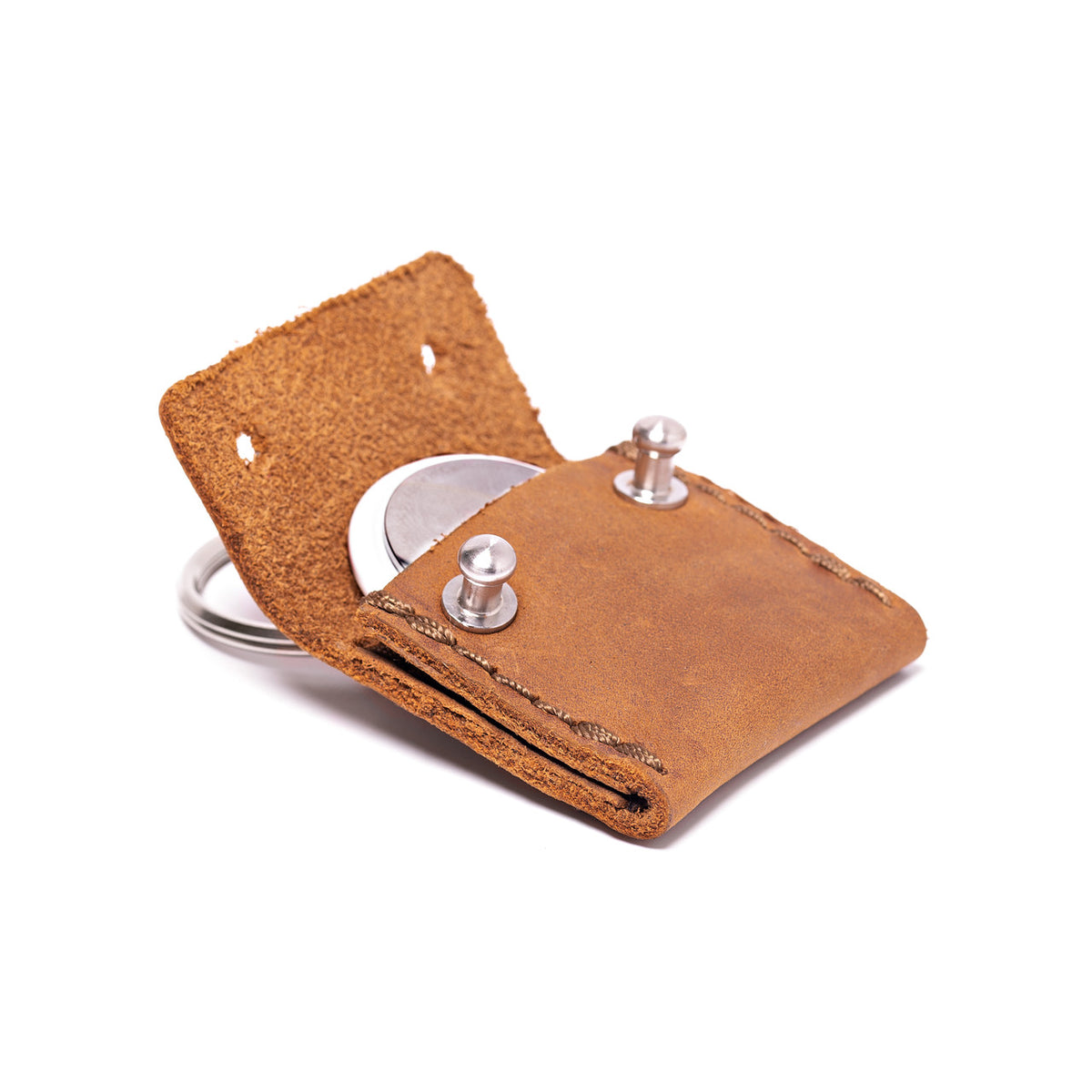 The Pouch Leather AirTag Keychain Case in tan, close-up of open flap, AirTag and stud closures