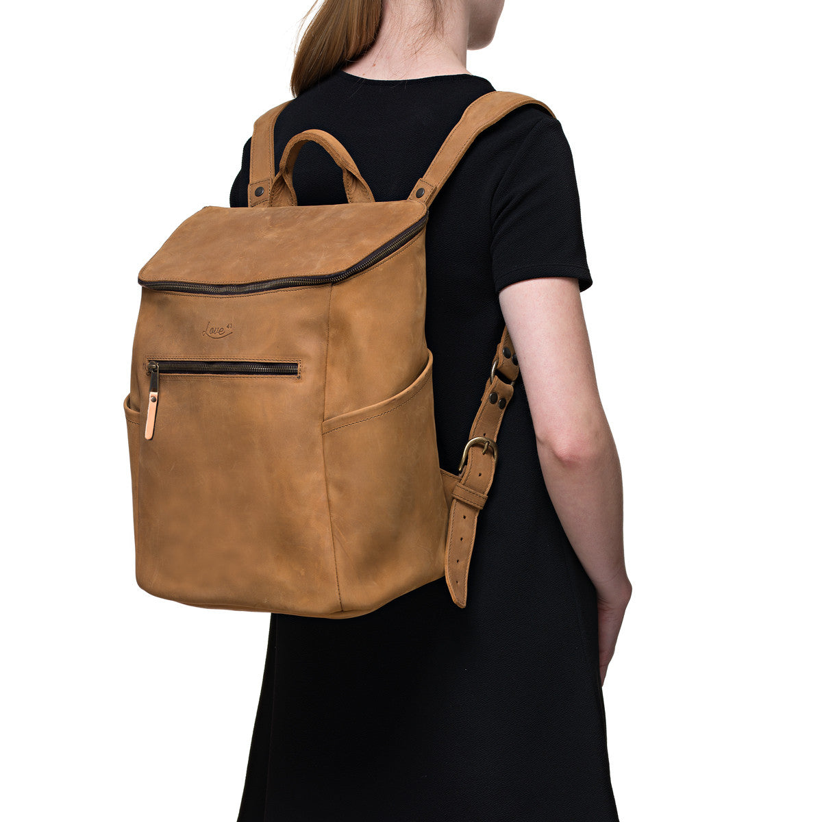 All in One Leather Backpack in Tobacco worn by a woman in a black dress, rear angled view