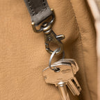 All in One Leather Backpack interior key clip on a leather strap holding a set of keys against tan lining