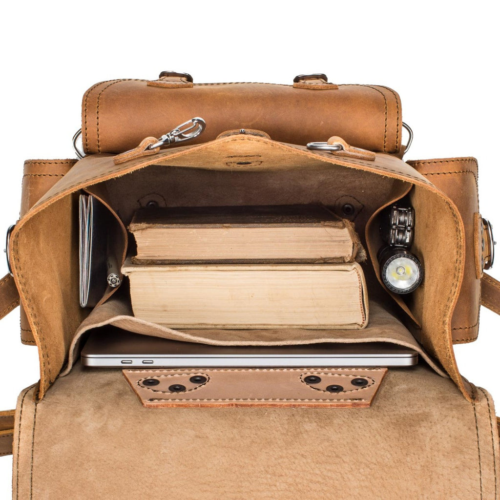 Front Pocket Leather Backpack in Tobacco, top view open with books, a laptop and a flashlight inside