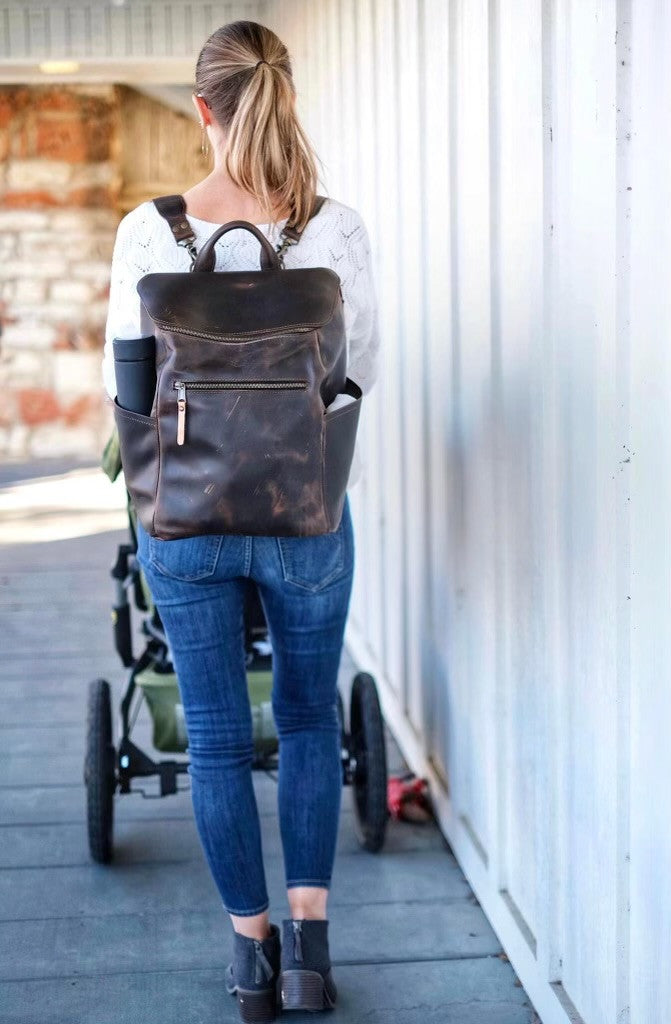 All in One Leather Backpack in Dark Coffee Brown worn by a woman pushing a stroller, rear view