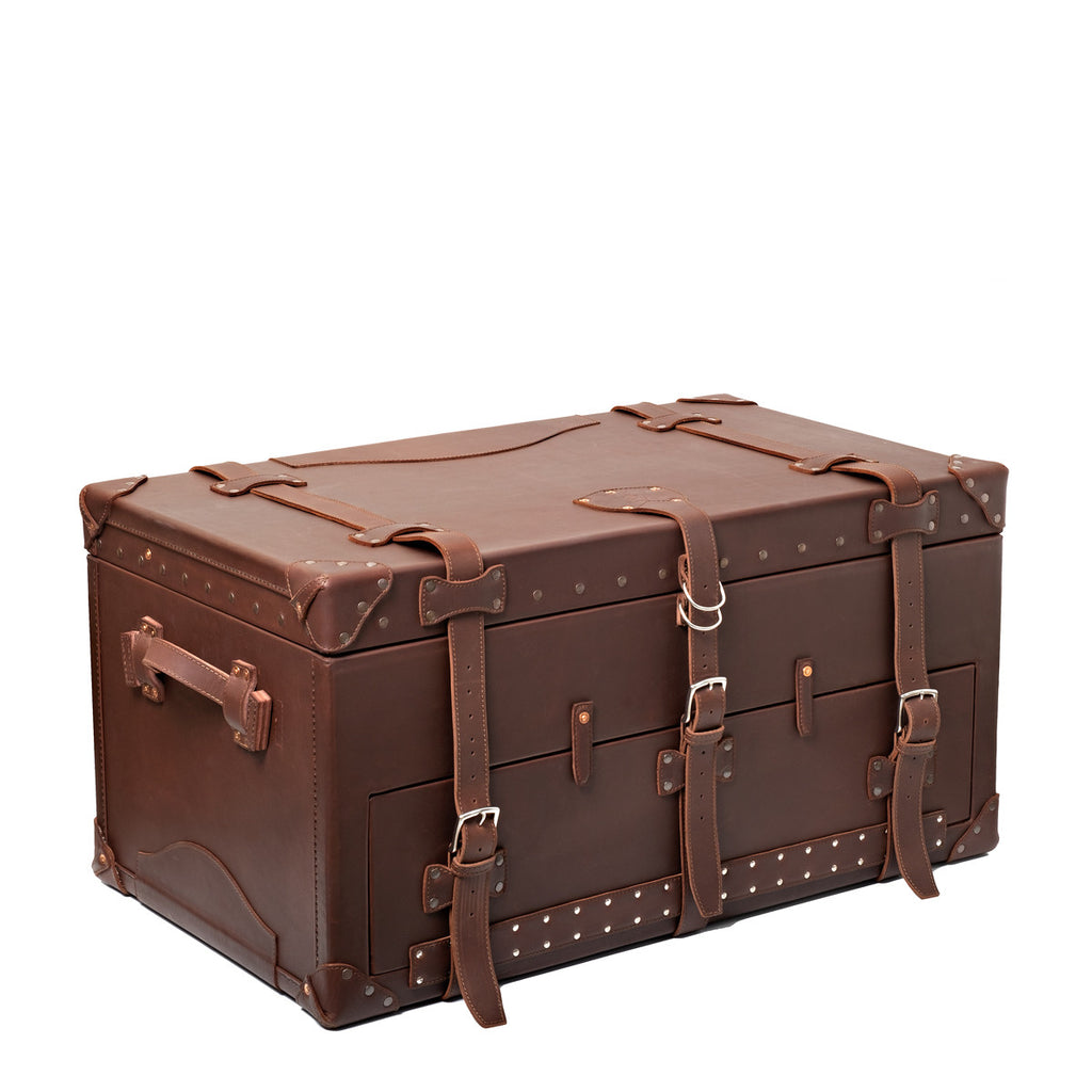 Leather Trunk in Chestnut, closed angled view with buckled straps, side handle and studded trim