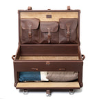 Leather Trunk in Chestnut, open with three buckled lid pockets and a drop-front drawer holding folded sweaters