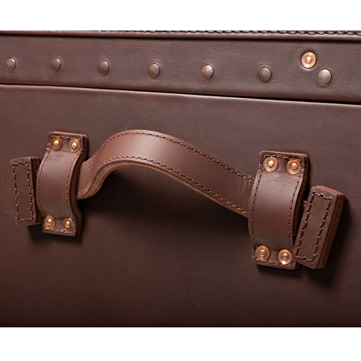 Leather Trunk in Chestnut, close-up of riveted side carry handle below studded trim