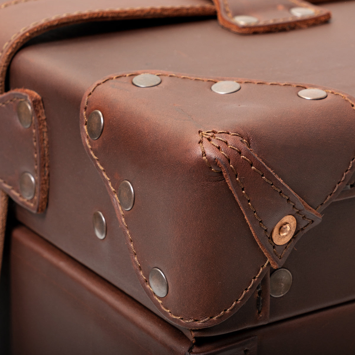 Leather Trunk in Chestnut, close-up of studded leather corner guard with copper rivet