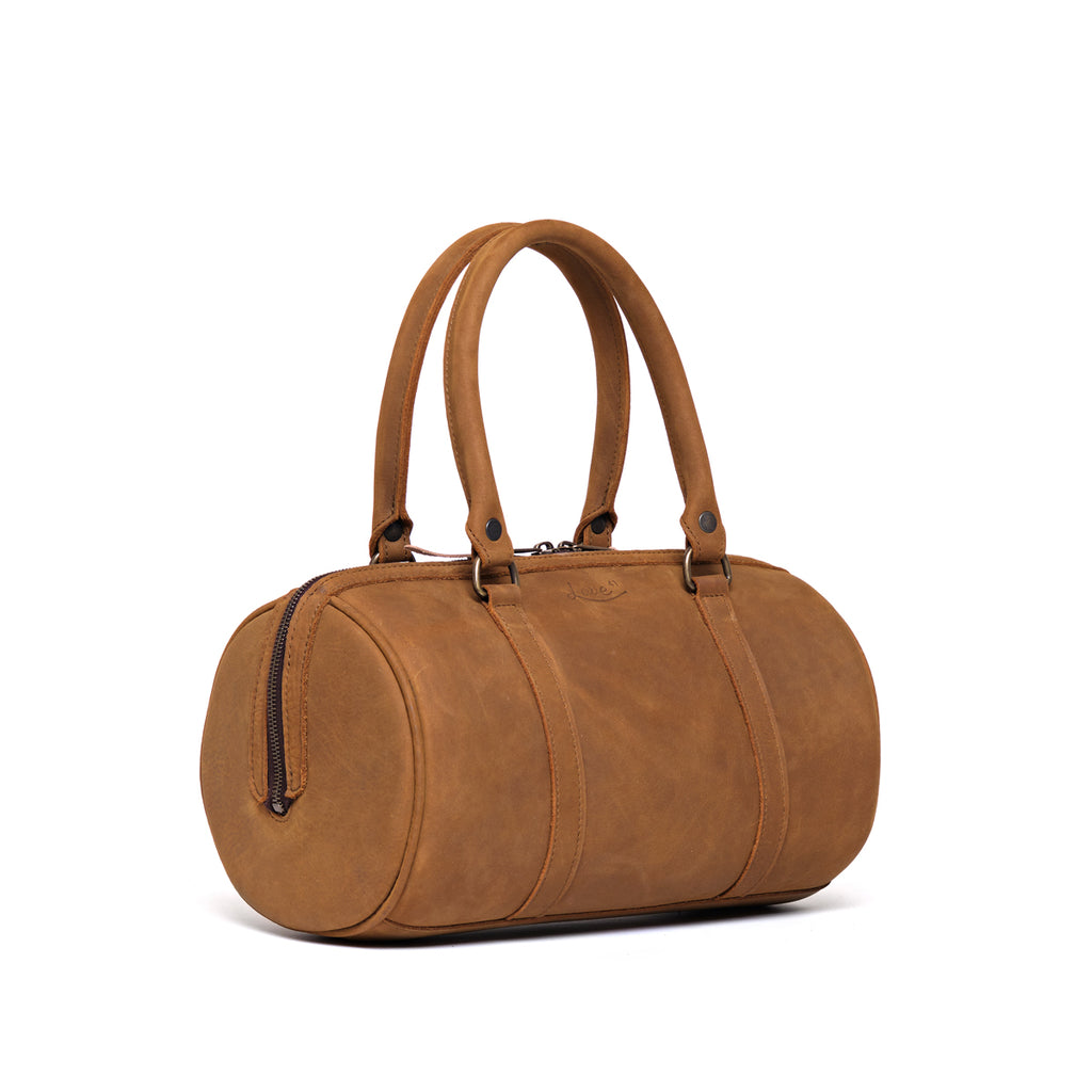 Everyday Barrel Bag in Tobacco, angled view showing the round end with zippered pocket